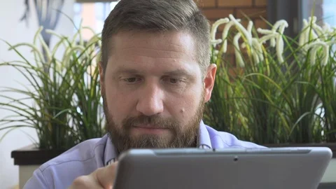 Businessman browsing tablet computer, look at camera, close steadycam portrait  库存影片 73333450