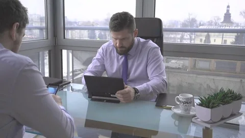 Businessman browsing tablet computer, talking by smartphone, in work, office Vídeo Stock 73225063