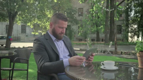 Businessman browsing tablet during coffe break. Outdoor. Steadicam shot. 库存影片 65362915