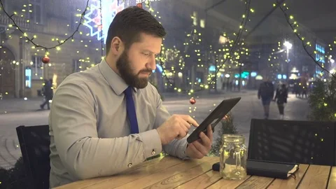 Businessman browsing tablet, evening, cafe, christmas time, close shot 库存影片 72998932