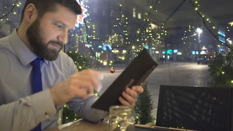 Businessman browsing tablet, night, cafe, christmas, slider dolly close shot Vidéo 72998935