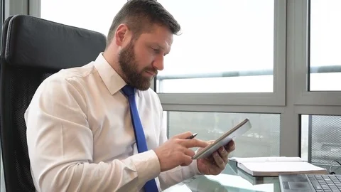 Businessman browsing tablet in the office, slider pan shot, left Vidéo 72362098