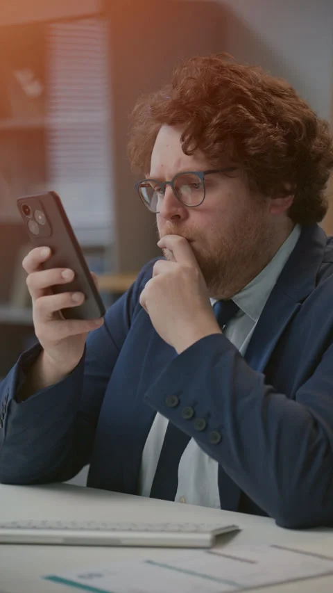 Businessman Browsing the Web on Smartphone during Office Workday Stock Footage 331558374