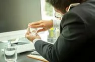 Businessman Busy Talking On Cell Phone And Taking Pills At Work Desk In Offic Stock Photos