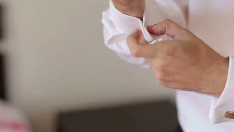 Businessman buttoning cuff links on his shirt. CU Stock Footage 82709308