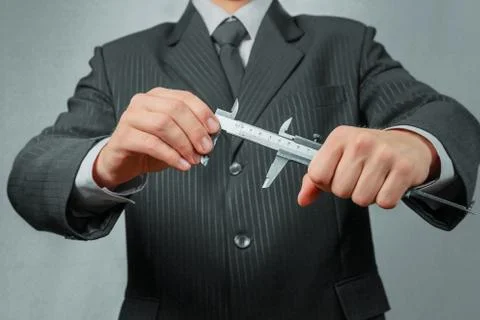 Businessman with calipers Stock Photos