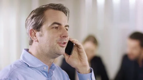Businessman is calling a client while businessgroup is sitting in the background Stock Footage 72338073