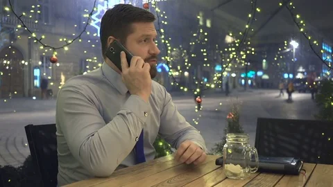Businessman calling by smartphone, smiling at camera, at night, in cafe 库存影片 72998769