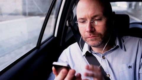 Businessman in the Car Looking at His Mobile Phone Stock Footage