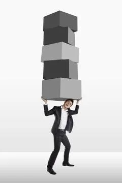 Businessman carrying a stack of cubes 스톡 사진