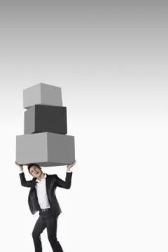 Businessman carrying a stack of cubes 스톡 사진