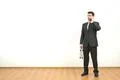 The businessman with a case phones on the white wall background Photo