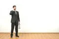 The businessman with a case phones on the white wall background Photo