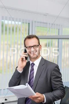 Businessman chatting on his phone in the office Stock Photos