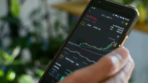 Businessman is checking Bitcoin price chart on crypto exchange on amobile phone 스톡 동영상 114985277