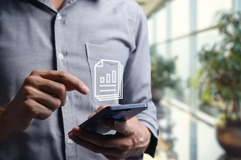Businessman Checking Document on Smartphone in Modern Office Setting Stockfoto's