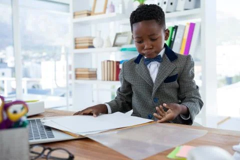 Businessman checking file while sitting at desk Stock Photos