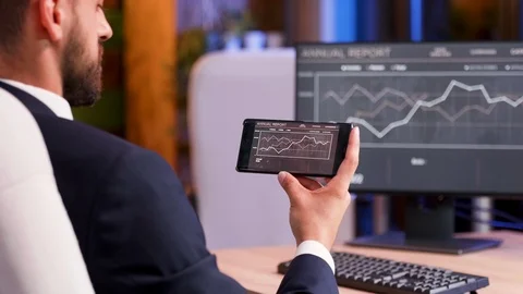 Businessman checking financial data on his phone, late at night Stock Footage 114980508