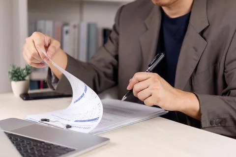 Businessman checking GPA calculator document and academic report for career.. Stock Photos