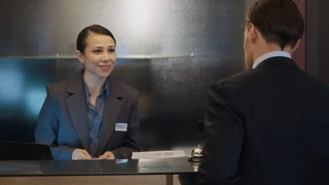 Businessman Checking into Hotel and Receiving Key Card from Receptionist Stock Footage 342127603