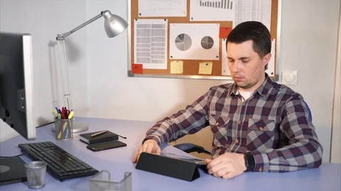 Businessman checking incoming mail on the tablet sitting in his office. Stock Footage 75962761