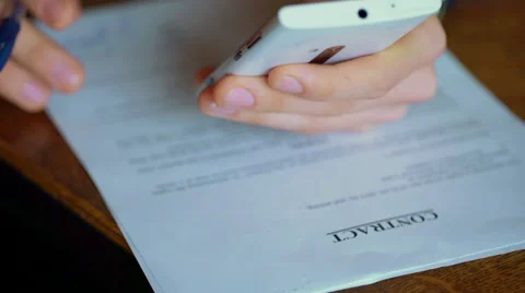 Businessman checking information on smartphone while having a contract to sign Stock-Footage 60970596