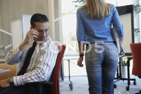 Businessman checking out female coworker Stock Photos
