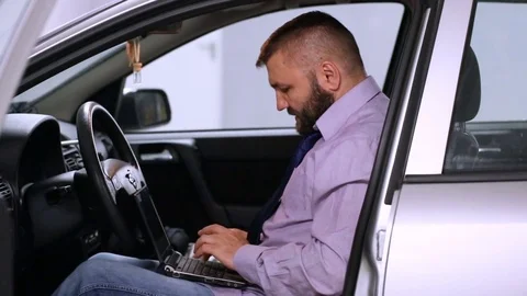 Businessman checking something on laptop while sitting in the car  Stock Footage 80396734