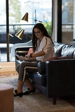 Businessman checking time while using laptop Stock Photos