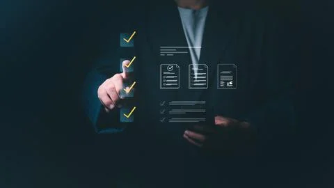 Businessman checking virtual boxes on a digital checklist for quality assur.. Fotos de archivo