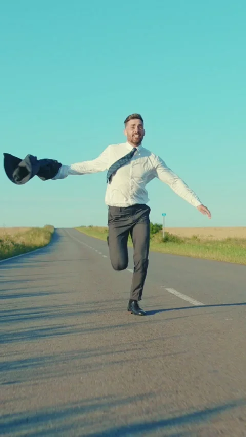 A businessman clad in a sharp suit is energetically running along a scenic Stock Footage 314366671