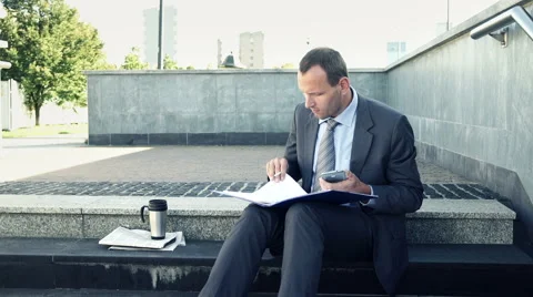 Businessman comapring data on smartphone and documents in the stairs HD Stock Footage 42135036