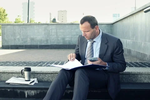 Businessman comapring data on smartphone and documents in the stairs NTSC Stock Footage 42135046