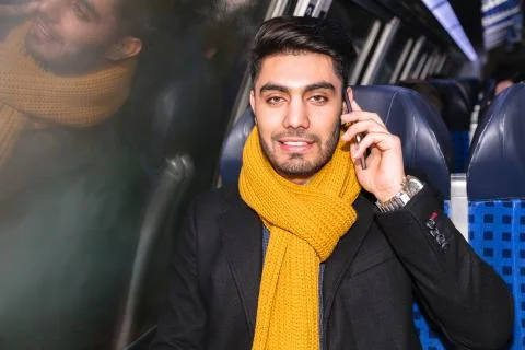 Businessman commuting to work on train using phone Stock Photos