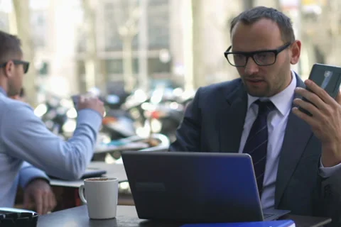 Businessman comparing data between a laptop and in a cellphone Stock Footage 38683935