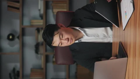 Businessman comparing data on laptop and in document at work Stock Footage 246415001