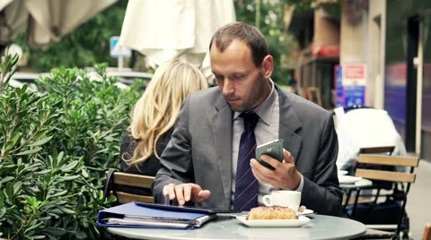Businessman comparing data on smartphone and tablet computer sitting in cafe HD Stock Footage 43338765