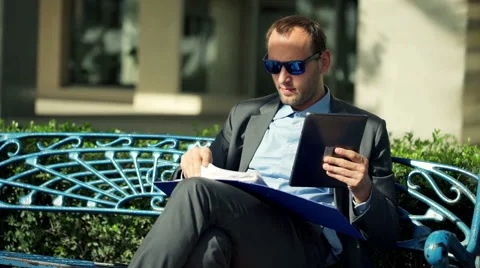 Businessman comparing data on tablet and documents in the city HD Stock Footage 44240622