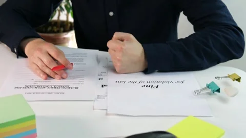 A businessman with construction documentation on his desk reads a fine for Stock Footage 313271111