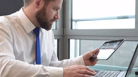 Businessman copying data from tablet to laptop in the office close shot Vídeo Stock 72362330
