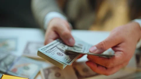 Businessman counting stack of hundred dollar bills in office as financial w.. Stock Footage 337467627