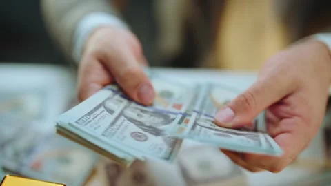 Businessman counting stack of one hundred dollar bills in office setting wh.. Stock Footage 337597917