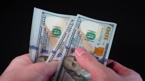 Businessman counting US Dollar bill or paying in cash on money black background Stock Photos
