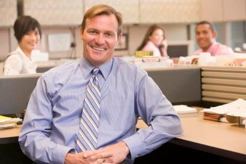 Businessman in cubicle smiling Stock Photos