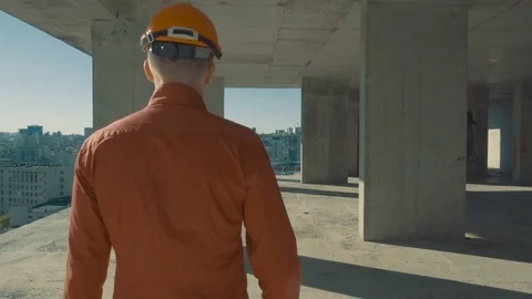 Businessman developer with open arms satisfied the bypass of the building Stock Footage 76539679