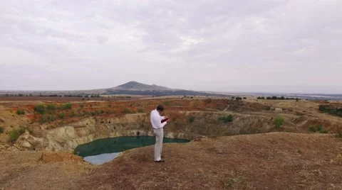 Businessman developing concept ideas in front of water reservoir Stock Footage 67968434