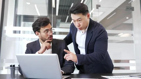 Businessman discussing with colleague at workplace using laptop computer  Stock Footage 299573902