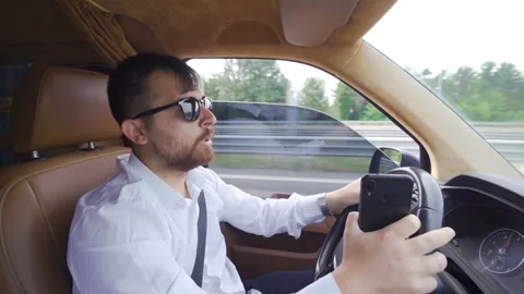 Businessman diving into the phone while driving. Stock Footage 212391568