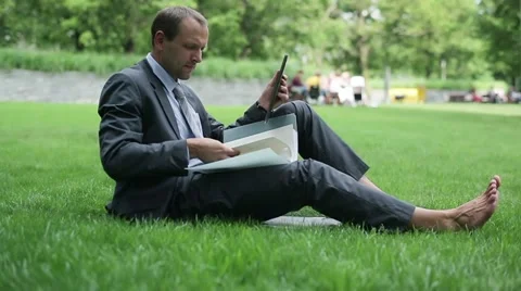 Businessman with documents chatting tablet computer in the park HD Stock Footage 11513984