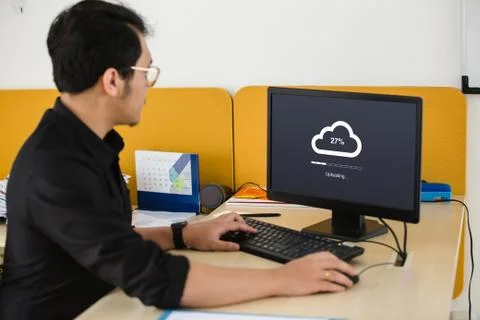 Businessman doing cloud uploading on computer at office Stock Photos